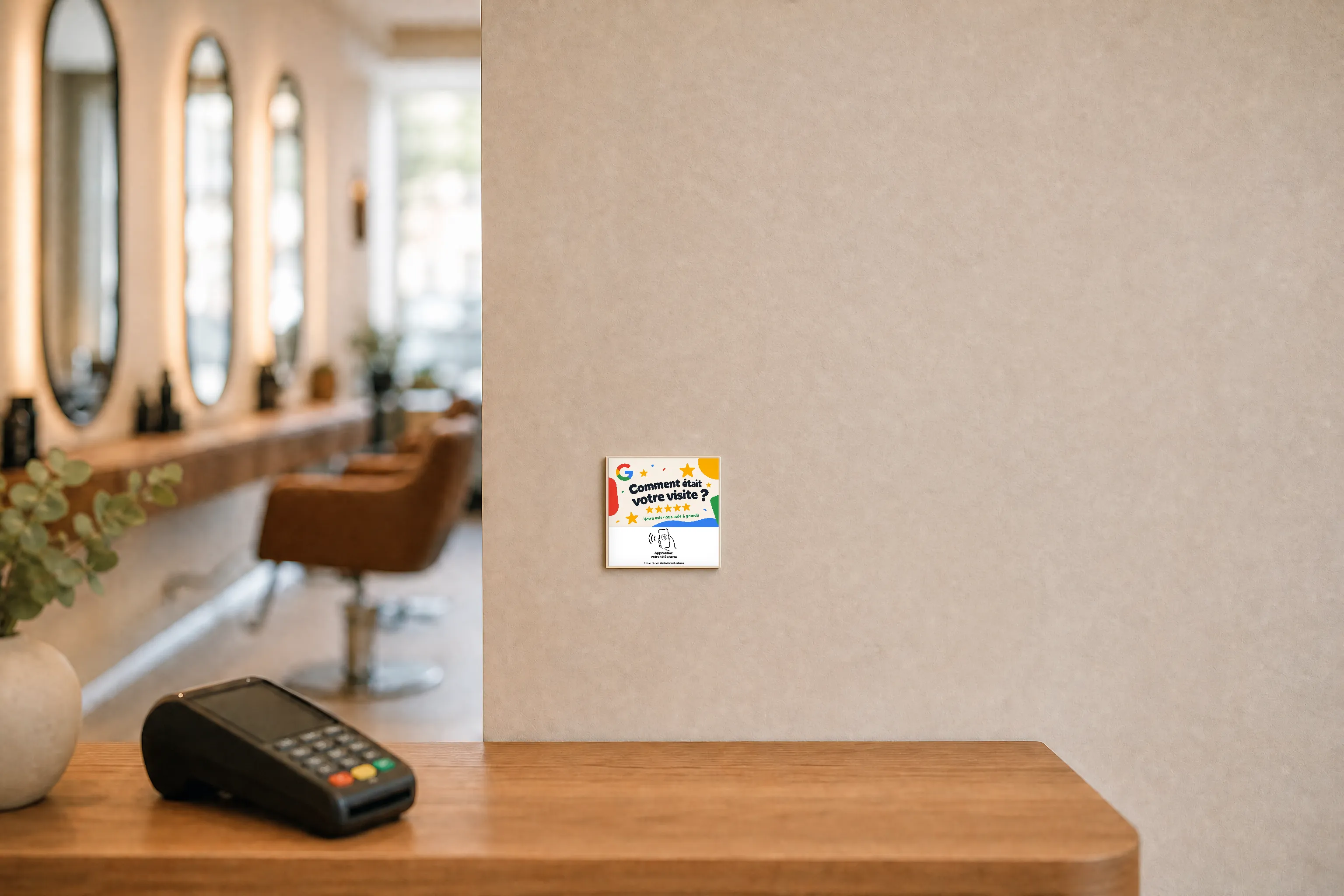 La plaque Avisdirect collée au mur à hauteur d'yeux à côté de la banque d'accueil d'un salon de coiffure, terminal de paiement posé dessous